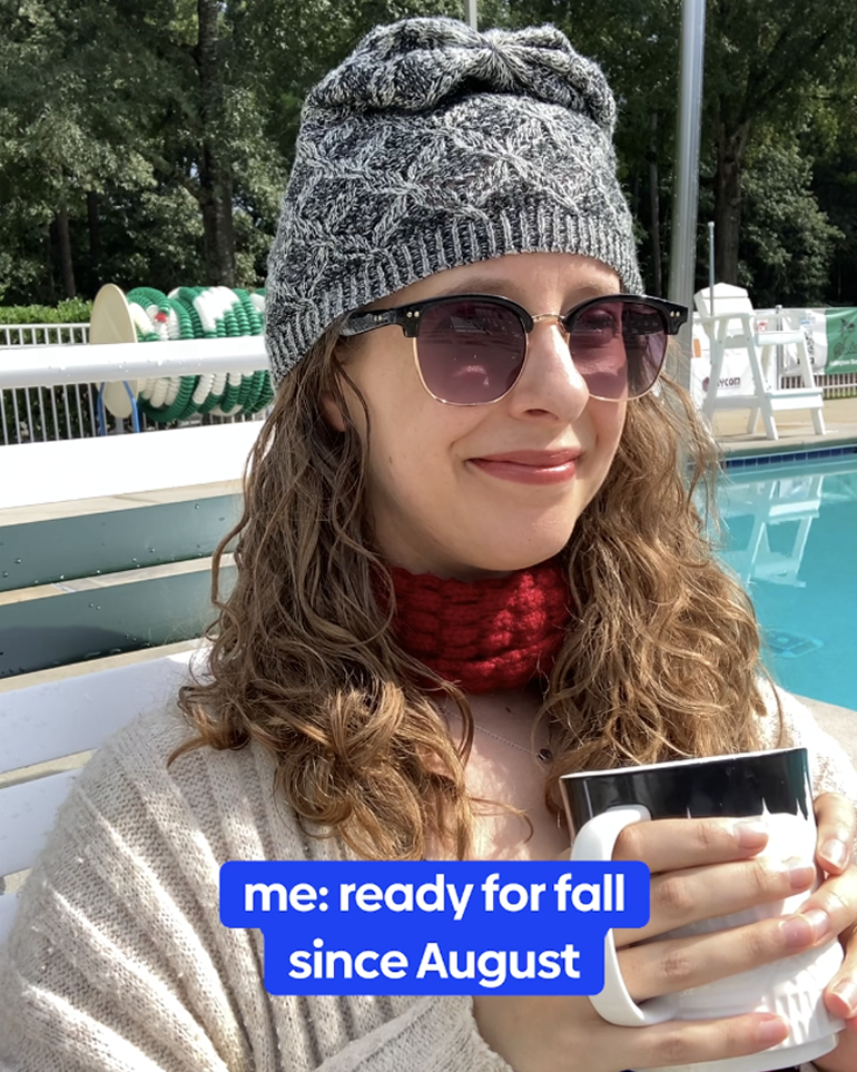 A woman at a pool dressed in fall attire.