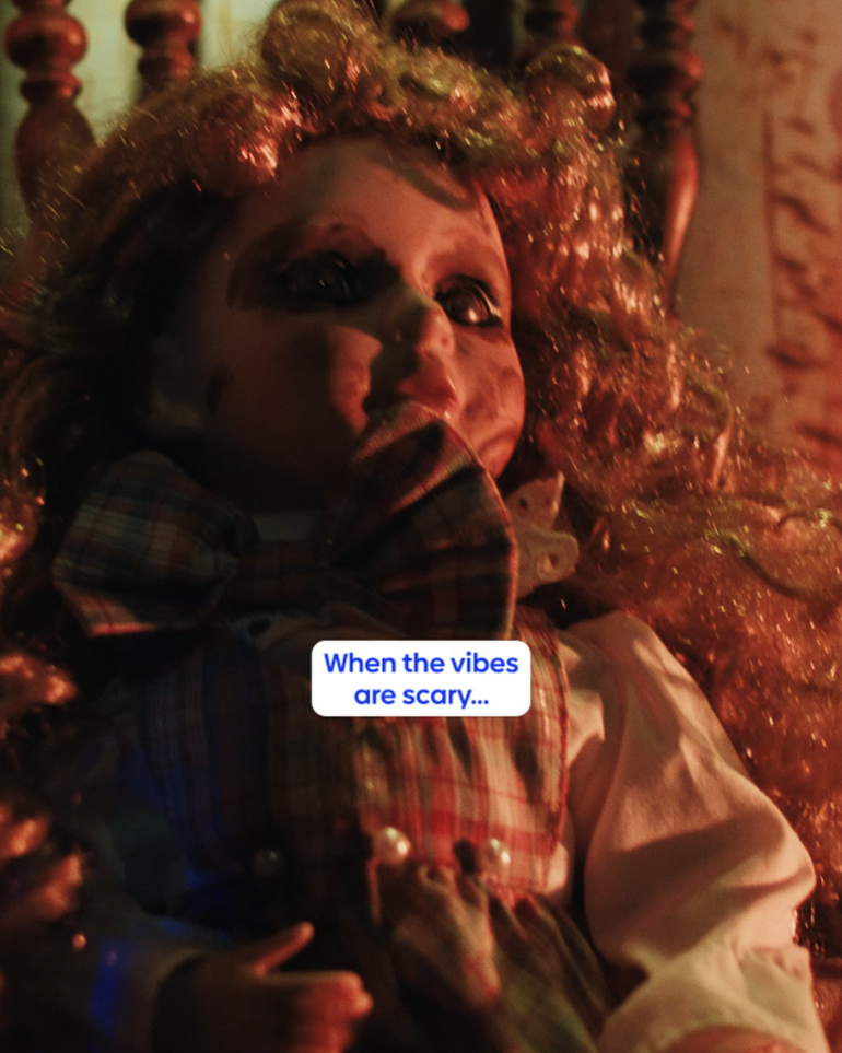 A creepy doll with a messed up face sitting on a rocking chair.