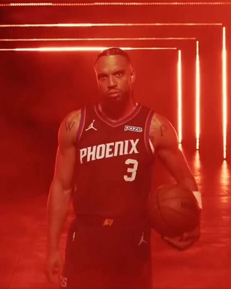 A Phoenix Suns player wearing a jersey with the Paze logo
